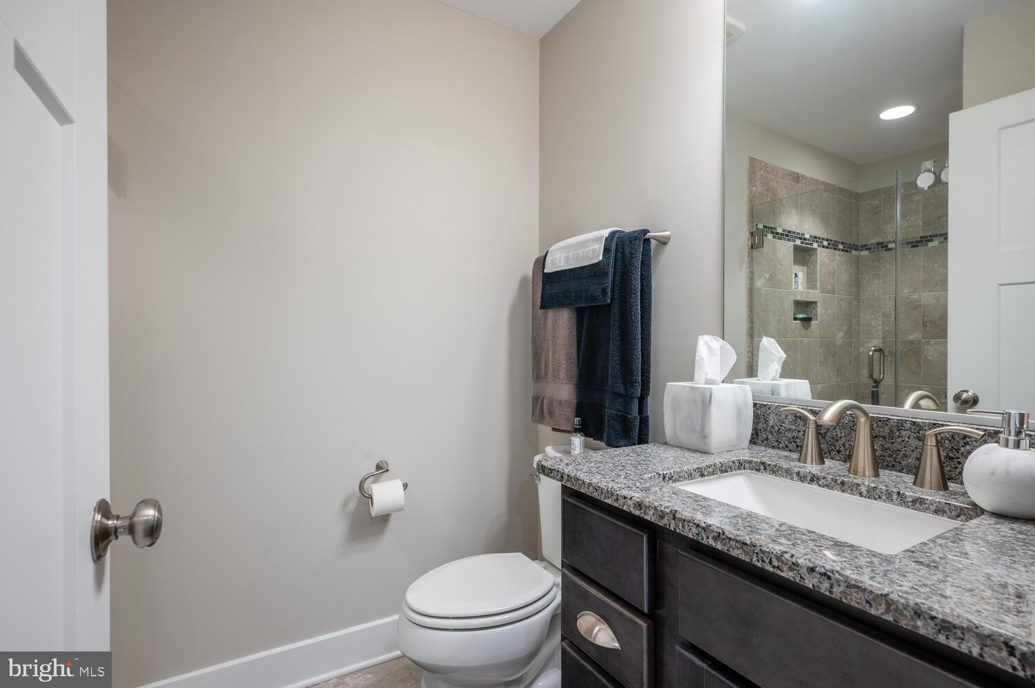 1126 North Stuart Street Arlington, VA 22201 - Photo 15 of 38 a bathroom with a granite countertop sink a toilet and a mirror