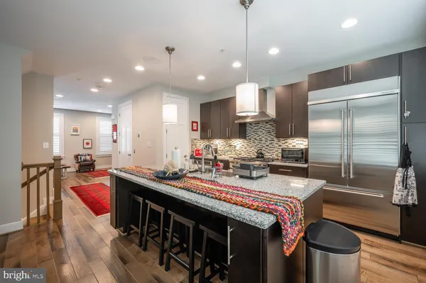 a kitchen with kitchen island granite countertop a stove a sink and wooden cabinets