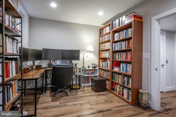 a view of a workspace with furniture and a book shelf