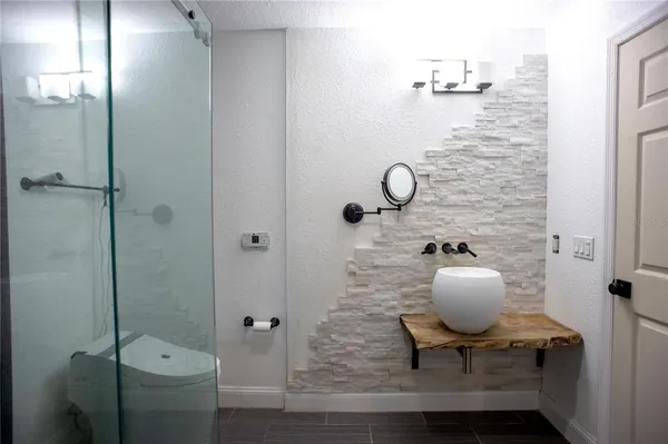 a bathroom with a sink a toilet and shower