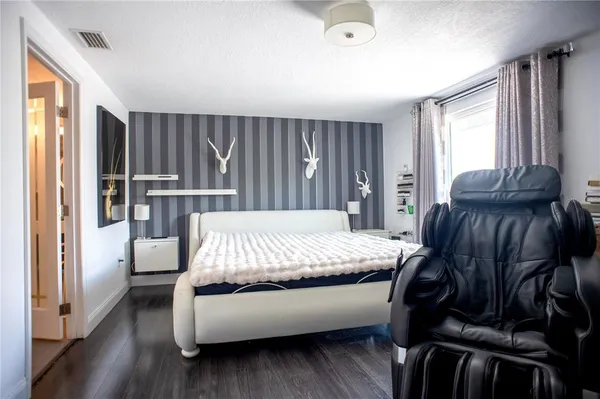 a bed room with a bed and a chair