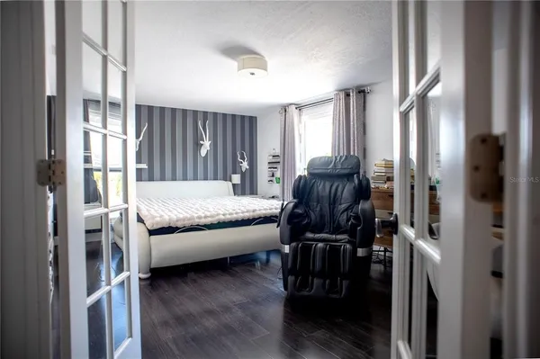 a bedroom with a bed and wooden floor