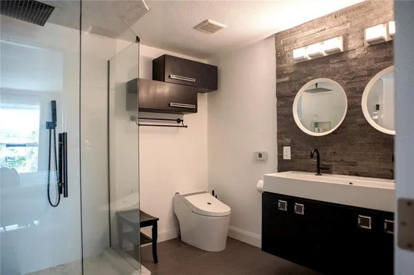 a bathroom with a toilet a sink and a mirror