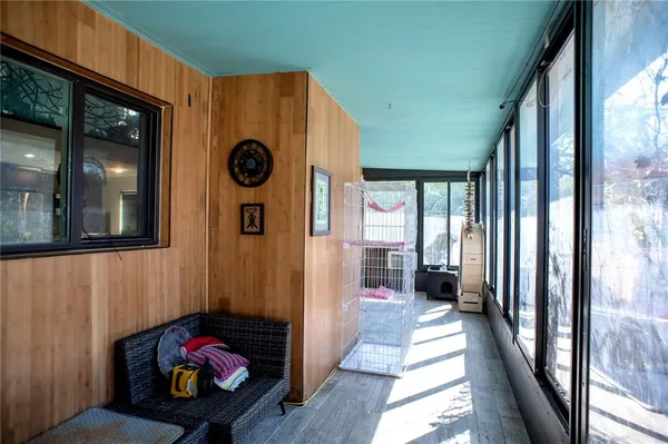 a view of a hallway with wooden floor and windows