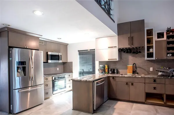 a kitchen with stainless steel appliances granite countertop a refrigerator stove and sink