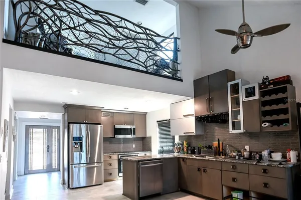 a kitchen with stainless steel appliances granite countertop a refrigerator a stove and a sink