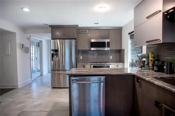 a kitchen with stainless steel appliances a sink stove refrigerator and cabinets