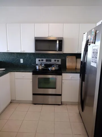 a kitchen with cabinets and steel stainless steel appliances