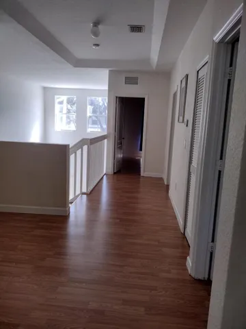 a view of a hallway with wooden floor