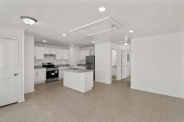 a kitchen with white cabinets and stainless steel appliances