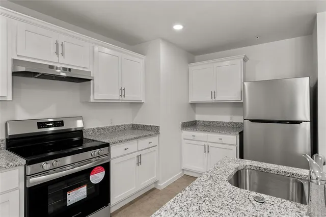 a kitchen with stainless steel appliances granite countertop a sink stove and refrigerator