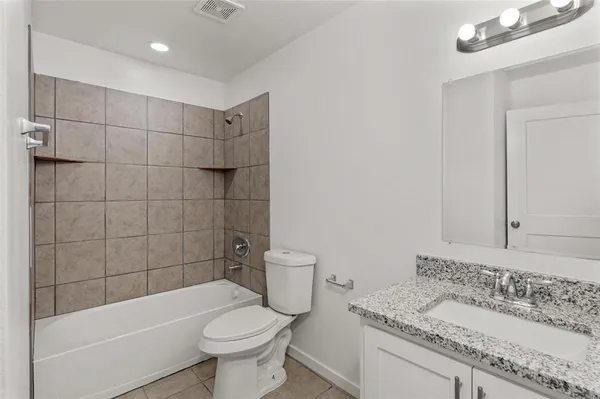 a bathroom with a granite countertop toilet a sink and bathtub