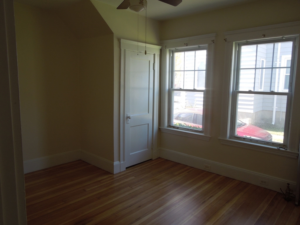 11 Clyde Road, Unit 11 Watertown, MA 02472 - Photo 4 of 7 an empty room with wooden floor and windows