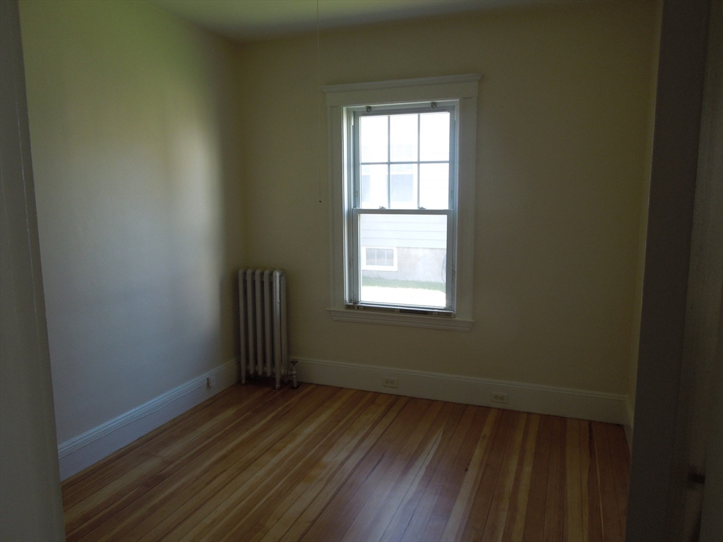 11 Clyde Road, Unit 11 Watertown, MA 02472 - Photo 6 of 7 an empty room with wooden floor and windows
