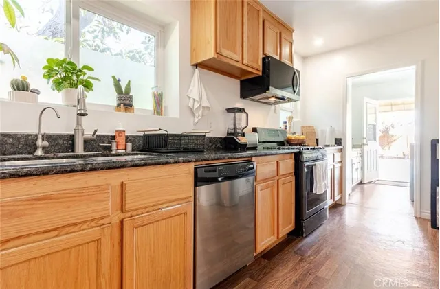 a kitchen with stainless steel appliances granite countertop a stove a sink and a microwave
