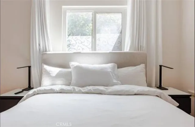 a bedroom with a large bed and a window