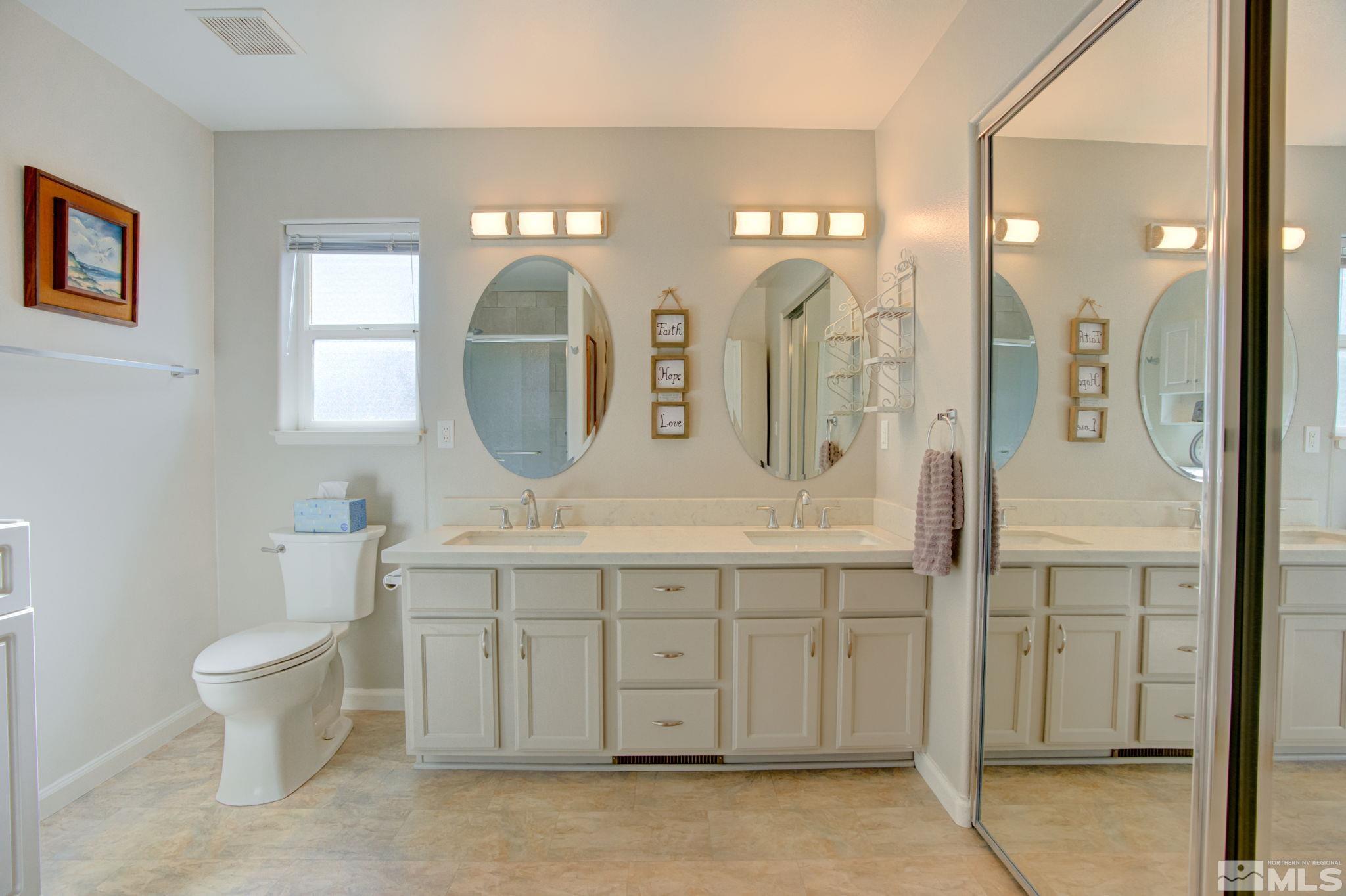 1315 Wrangler Circle Minden, NV 89423 - Photo 20 of 40 a spacious bathroom with a double vanity sink a toilet and a mirror