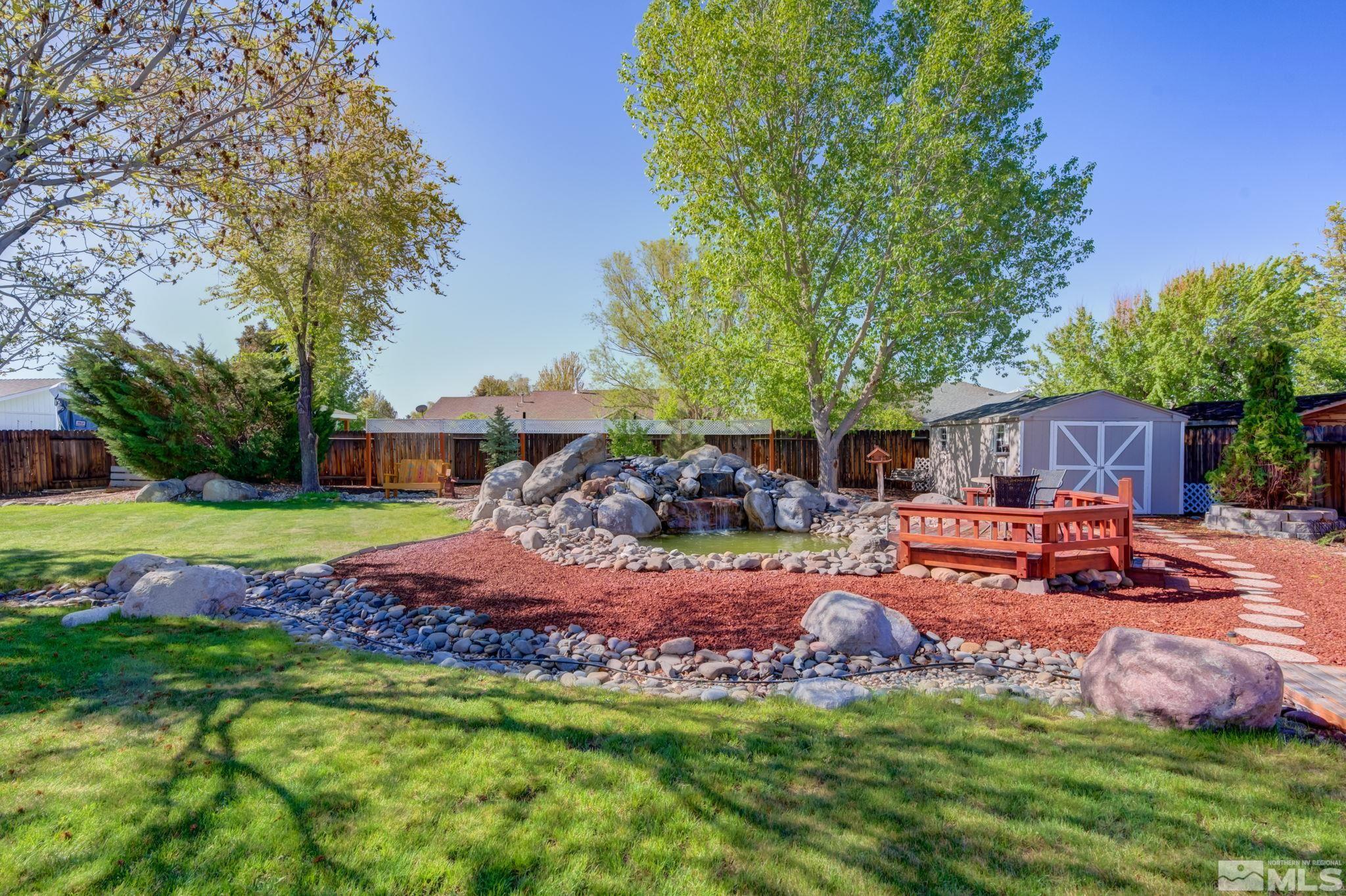 1315 Wrangler Circle Minden, NV 89423 - Photo 34 of 40 a view of a backyard with table and chairs potted plants and large tree