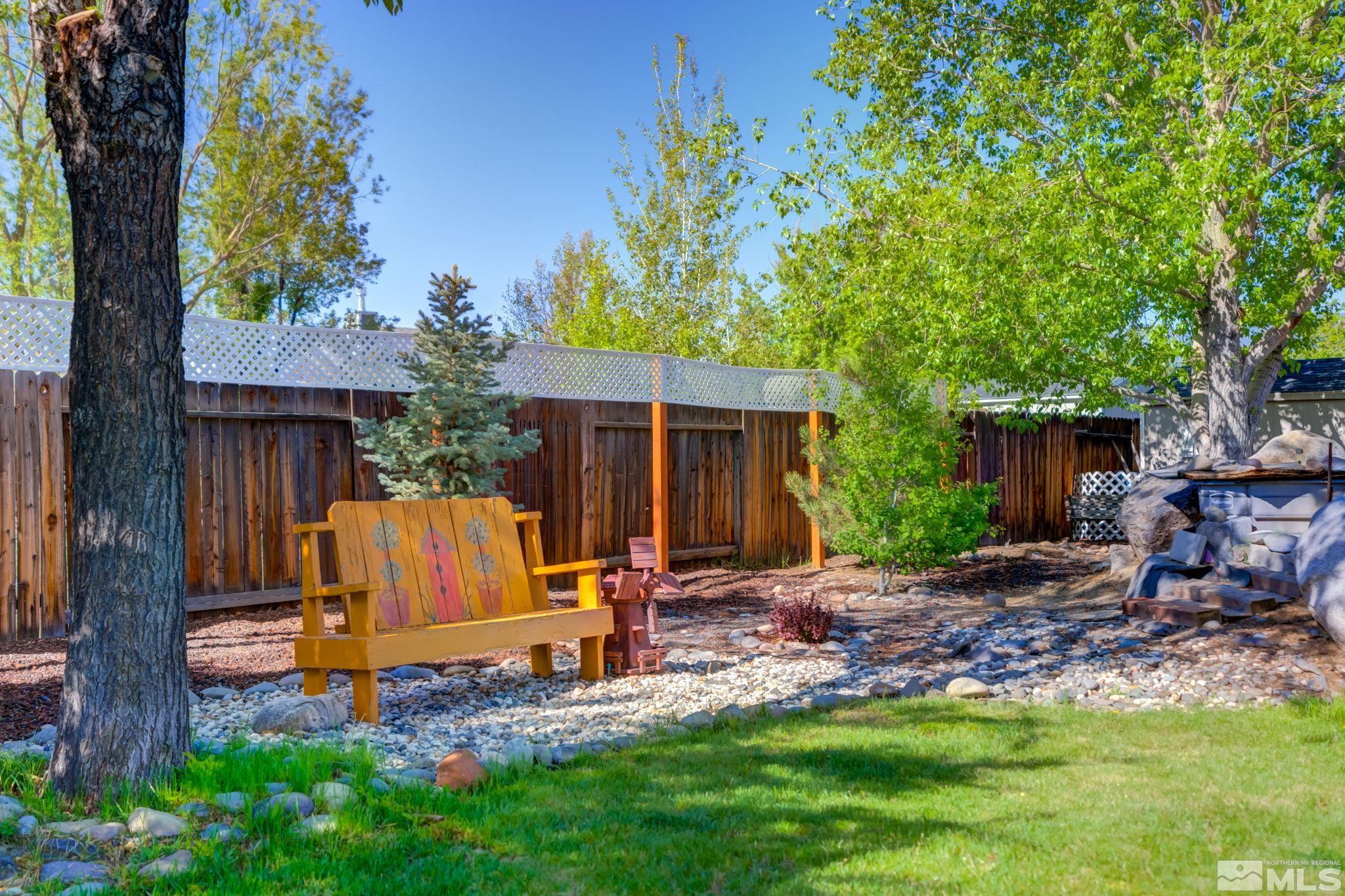 1315 Wrangler Circle Minden, NV 89423 - Photo 39 of 40 a view of a backyard with table and chairs potted plants and a large tree