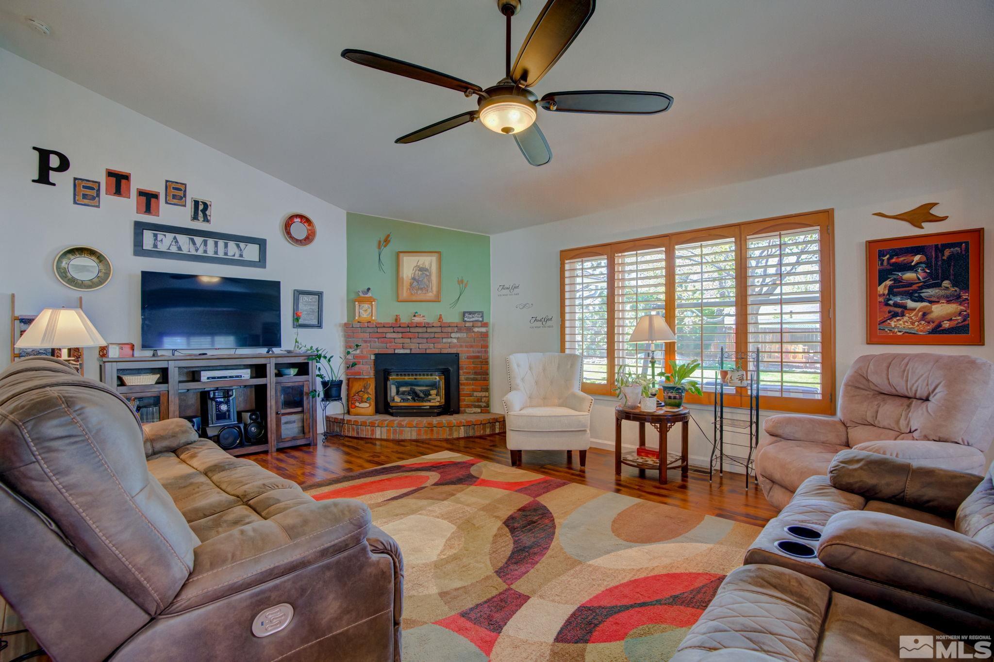 1315 Wrangler Circle Minden, NV 89423 - Photo 6 of 40 a living room with furniture a fireplace and a flat screen tv