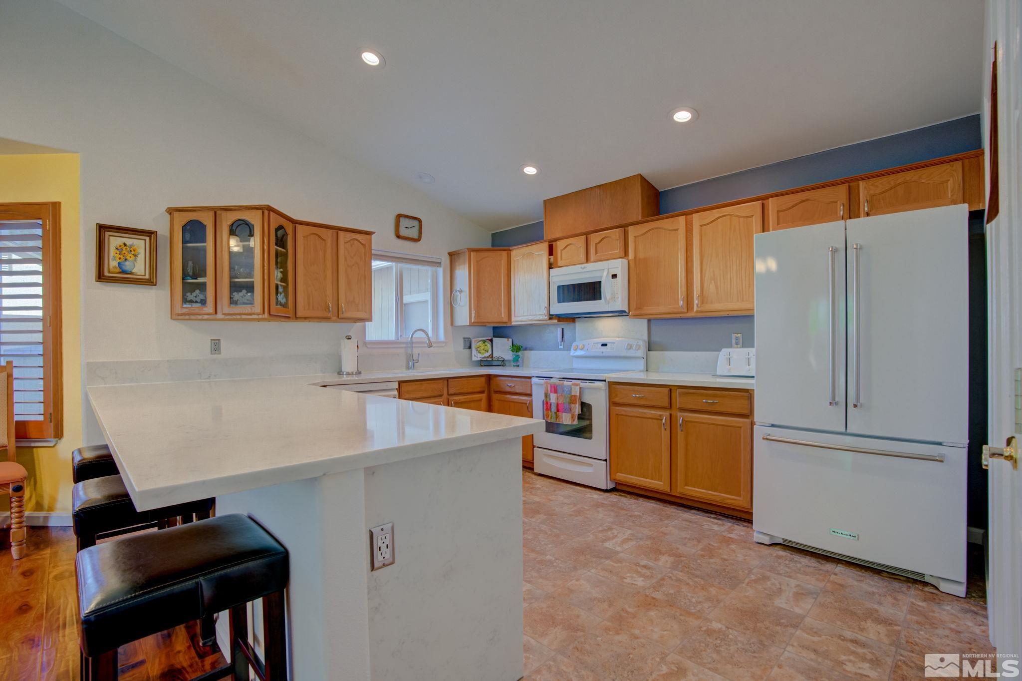 1315 Wrangler Circle Minden, NV 89423 - Photo 9 of 40 a kitchen with stainless steel appliances granite countertop a refrigerator and a stove top oven