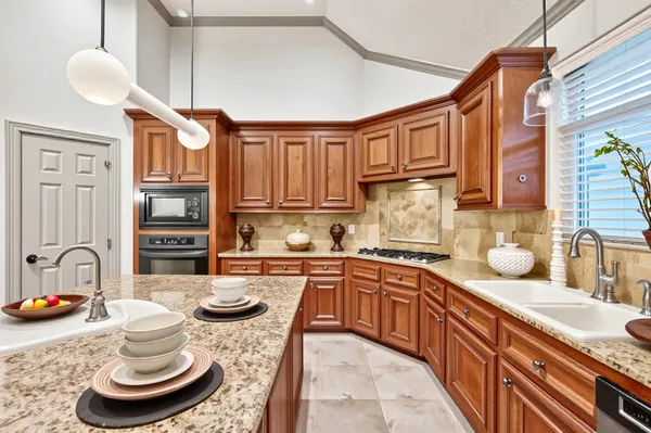 a kitchen with stainless steel appliances granite countertop a sink stove and cabinets