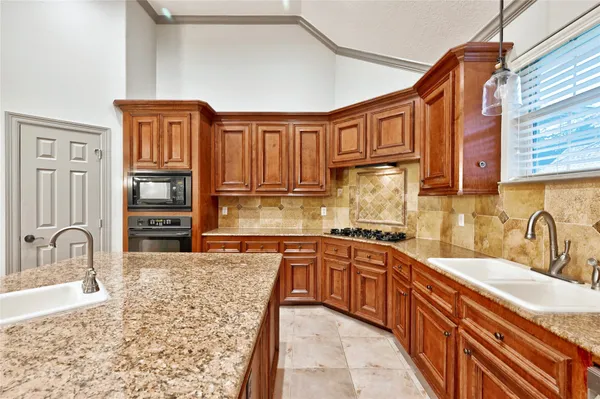 a kitchen with stainless steel appliances granite countertop a sink stove and cabinets