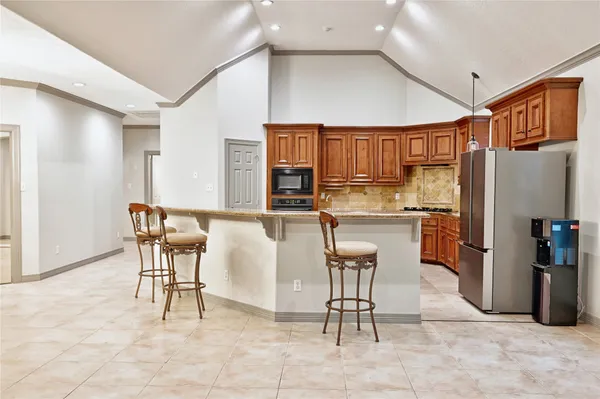 a kitchen with stainless steel appliances granite countertop a refrigerator and a stove top oven