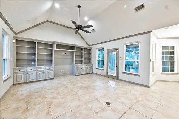a view of an empty room with a window and cabinet
