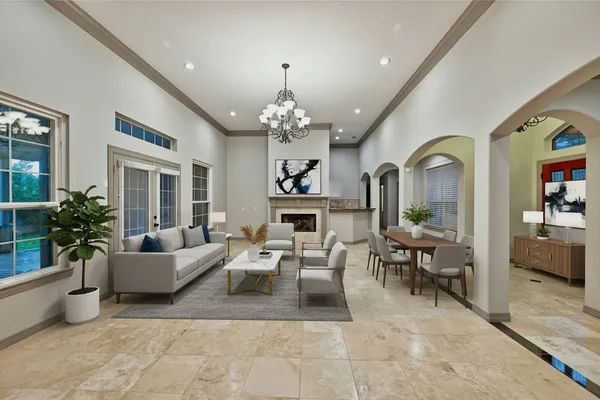 a living room with furniture a chandelier and a fireplace