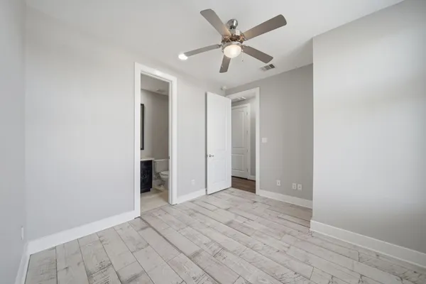 an empty room with closet and a ceiling fan