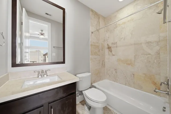 a bathroom with a granite countertop sink a toilet and shower