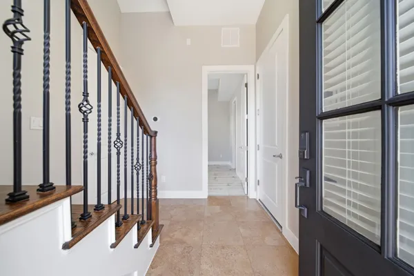 a view of a hallway with wooden floor and staircase