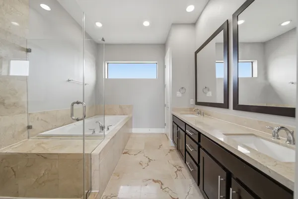 a spacious bathroom with a granite countertop sink a bathtub and a mirror