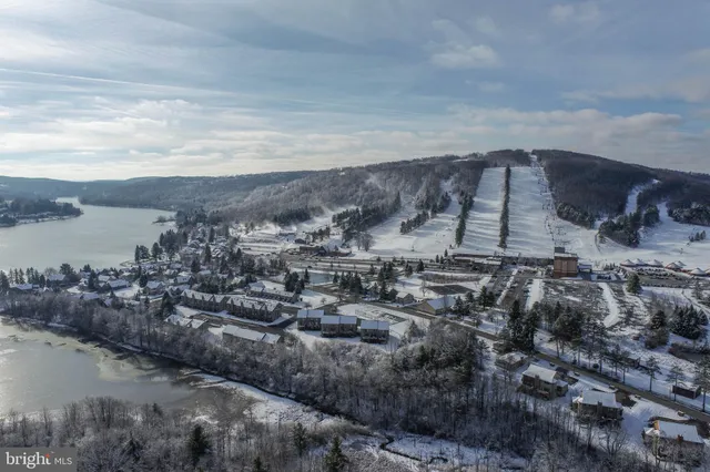 an aerial view of a house with a yard and lake view