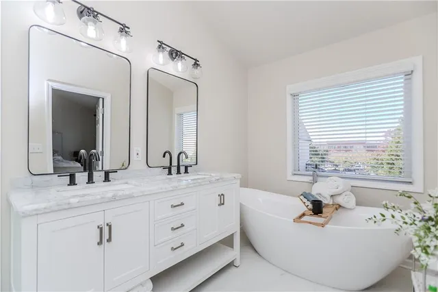 a bathroom with a double vanity sink mirror and shower