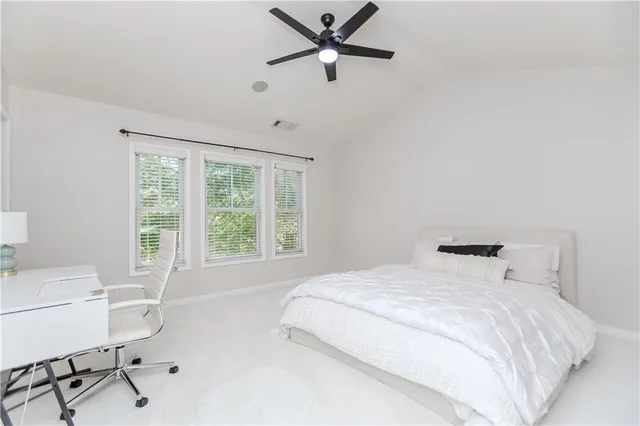 a bedroom with a bed tv and chair