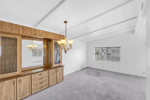 a view of an empty room with window and cabinet