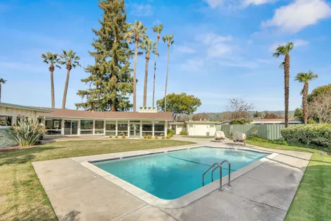 a living room with fireplace furniture and a large window