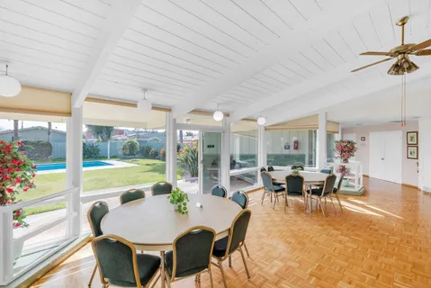 a room with pool table and windows