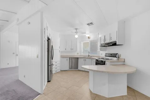 a kitchen with stainless steel appliances a sink stove and refrigerator