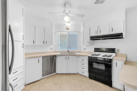 a kitchen with cabinets stainless steel appliances and a sink