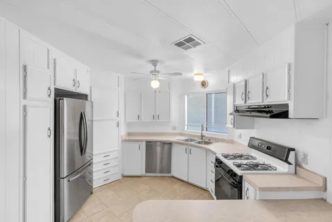 a kitchen with white cabinets and stainless steel appliances