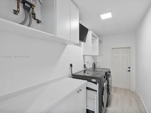 a room with a sink cabinets and wooden floor