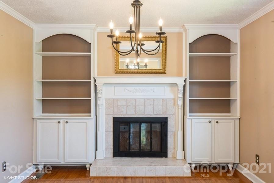 2564 Stroupe Road Clover, SC 29710 - Photo 11 of 29 a living room with a fireplace and a chandelier