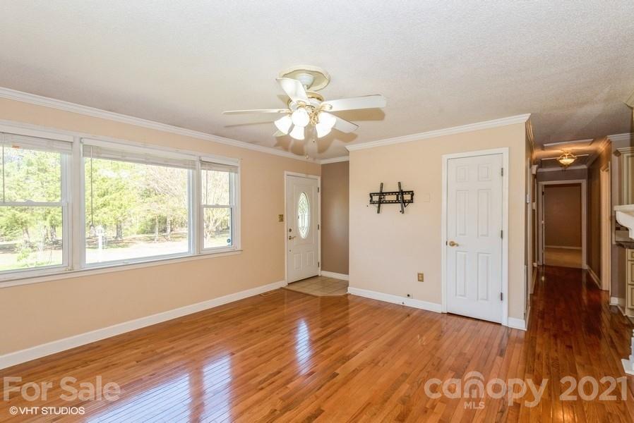 2564 Stroupe Road Clover, SC 29710 - Photo 19 of 29 an empty room with wooden floor chandelier fan and windows