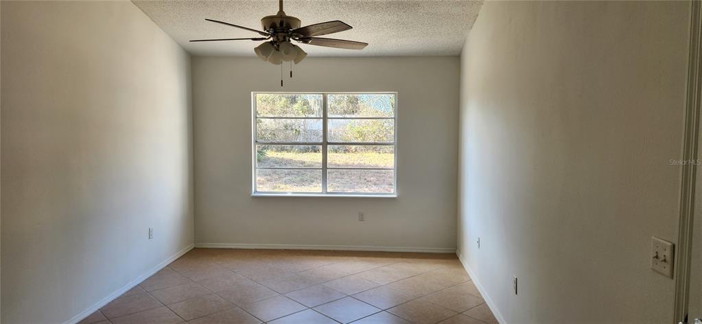 2856 Trenton Lane Deltona, FL 32738 - Photo 7 of 16 an empty room with a window and a fan