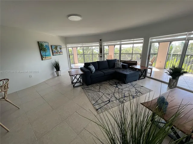 a living room with furniture large window and flat screen tv