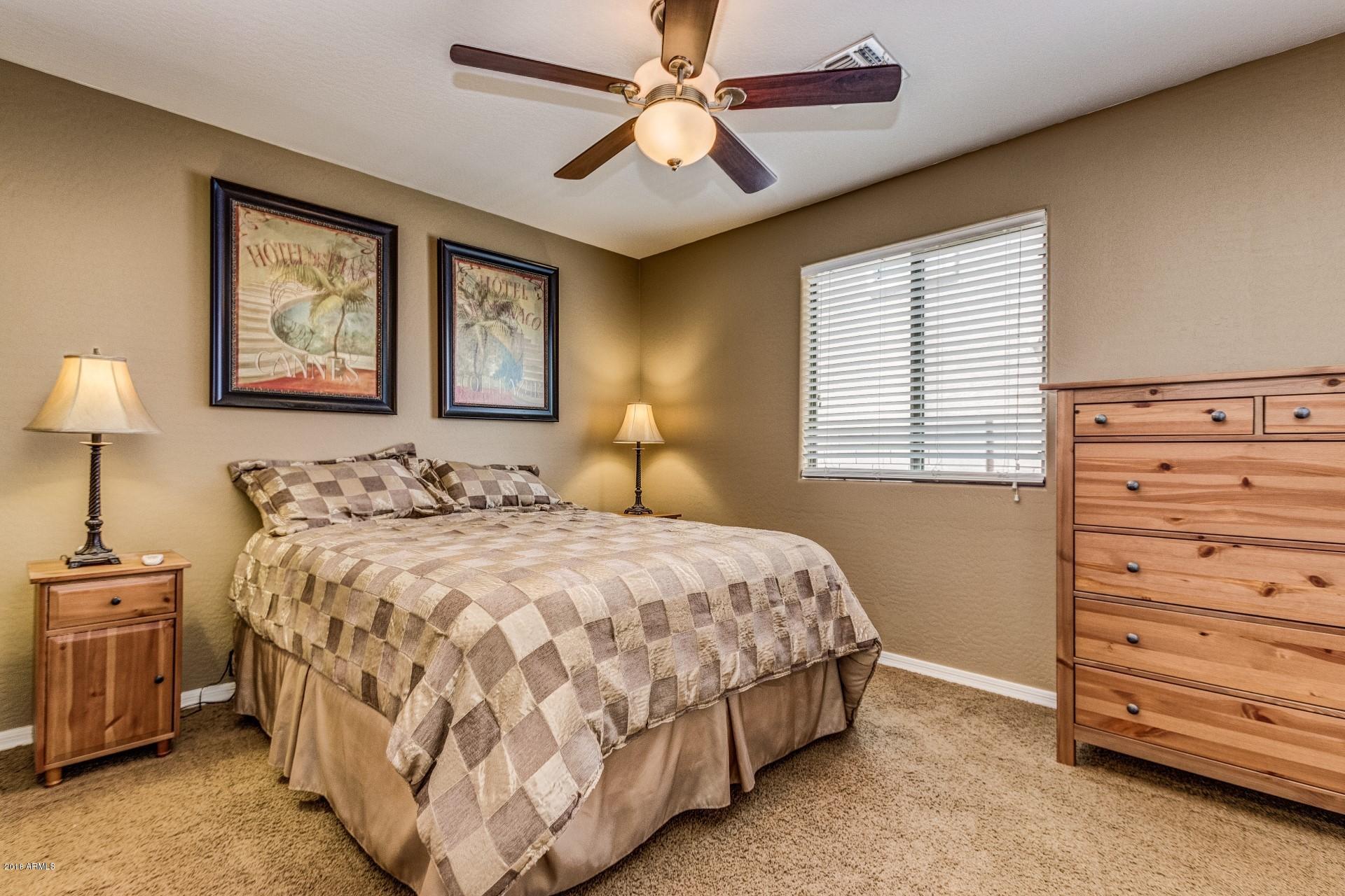 3927 East Blue Sage Road Gilbert, AZ 85297 - Photo 14 of 26 a bedroom with a bed and a ceiling fan
