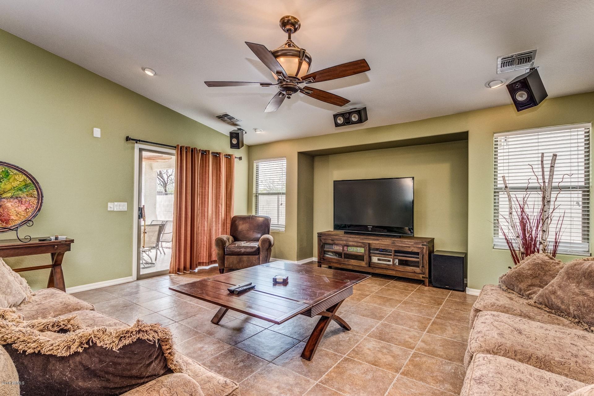 3927 East Blue Sage Road Gilbert, AZ 85297 - Photo 2 of 26 a living room with furniture and a flat screen tv